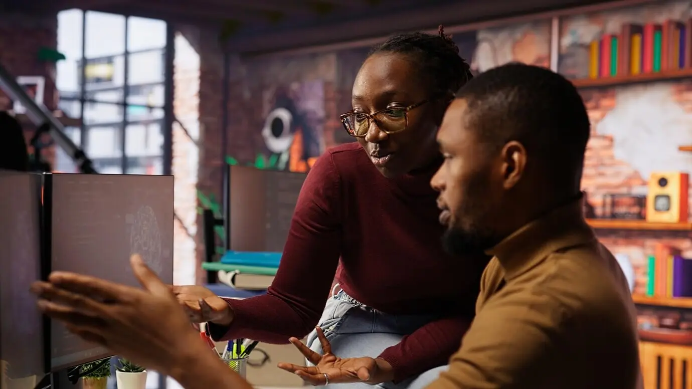 Collaborative coworkers monitoring an AI startup’s systems
